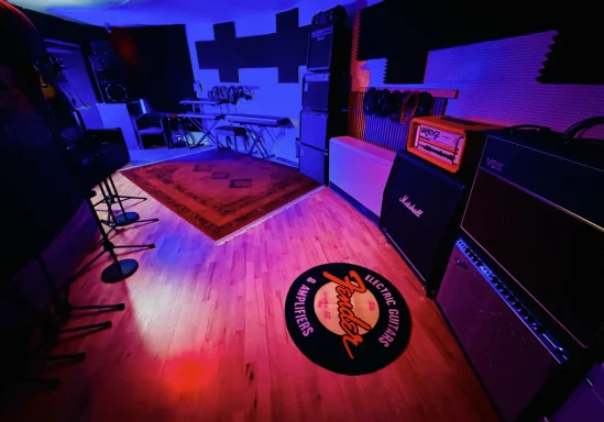 Aufnahmebereich mit Verstärkern, Teppich und bunten Lichtern.