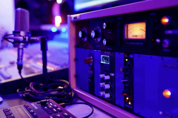 Mikrofon und Audiogeräte mit bunten Lichtern in einem Musikstudio.