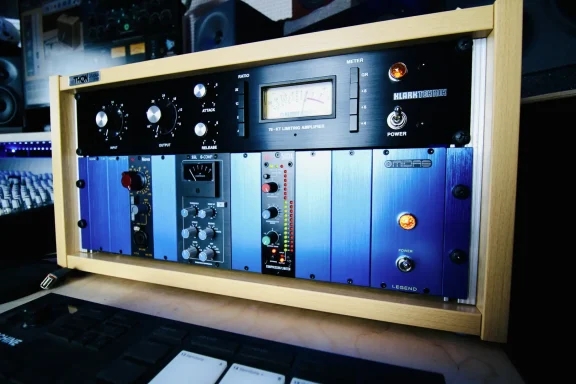 Analoges Mischpult mit verschiedenen Reglern und Geräten in blauer und schwarzer Farbe.