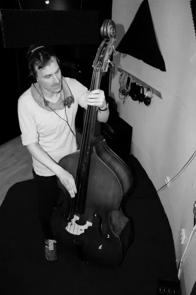 Ein Musiker spielt Kontrabass in einem Studio.
