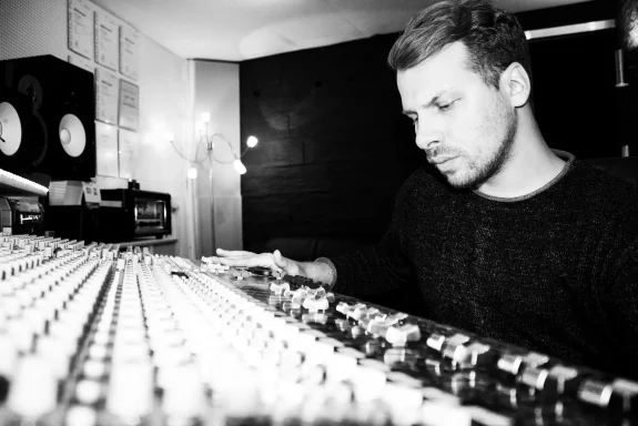 Mann an einem Mischpult, konzentriert beim Arbeiten im Tonstudio.